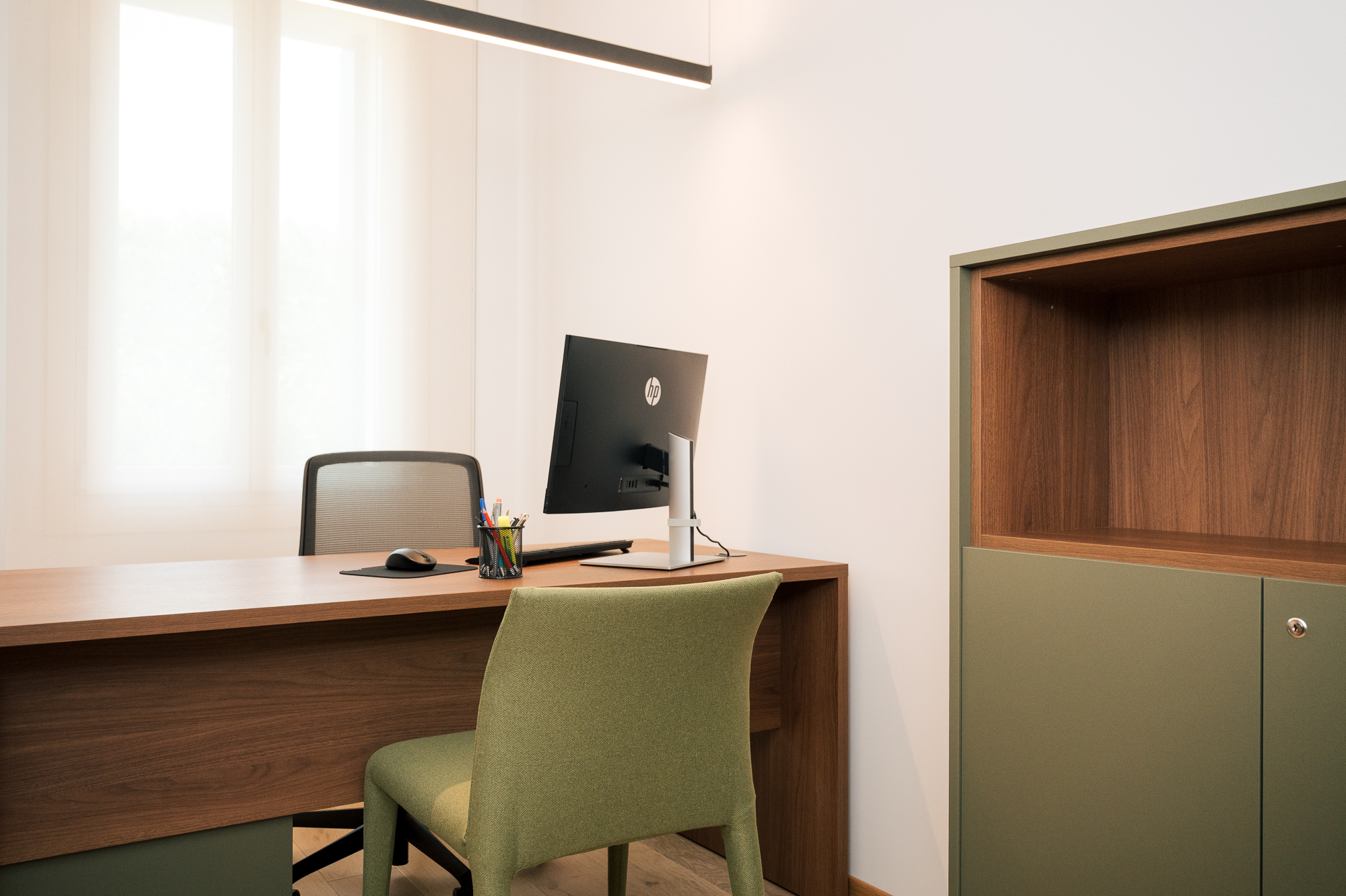 Ufficio contemporaneo in villa Liberty con scrivania in legno, arredi verdi e luce naturale
