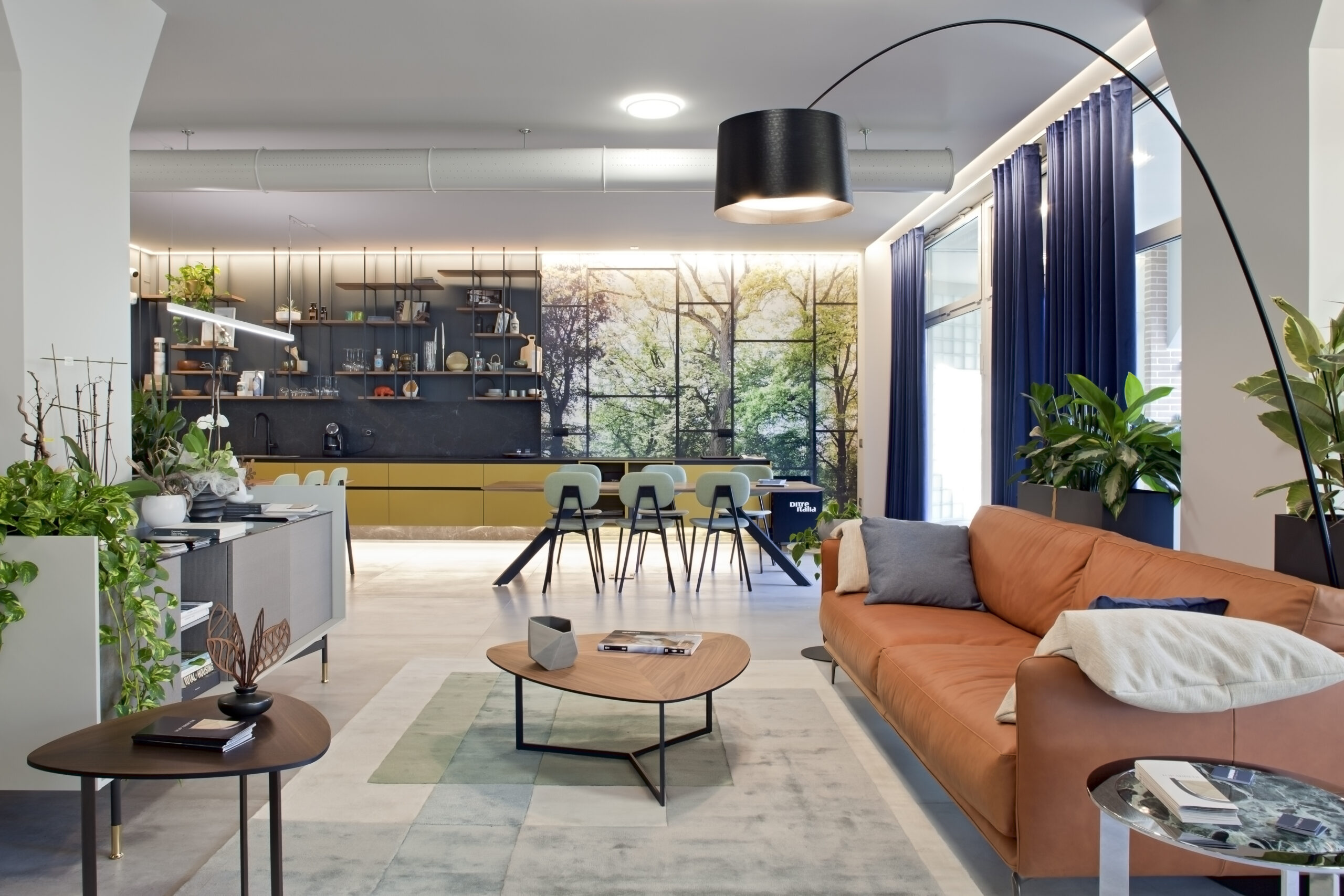 Ufficio contemporaneo con area lounge, divano in pelle e spazio riunioni sullo sfondo