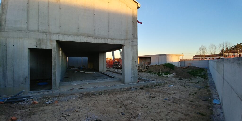 Casa in costruzione con grande apertura verso il patio e struttura in calcestruzzo