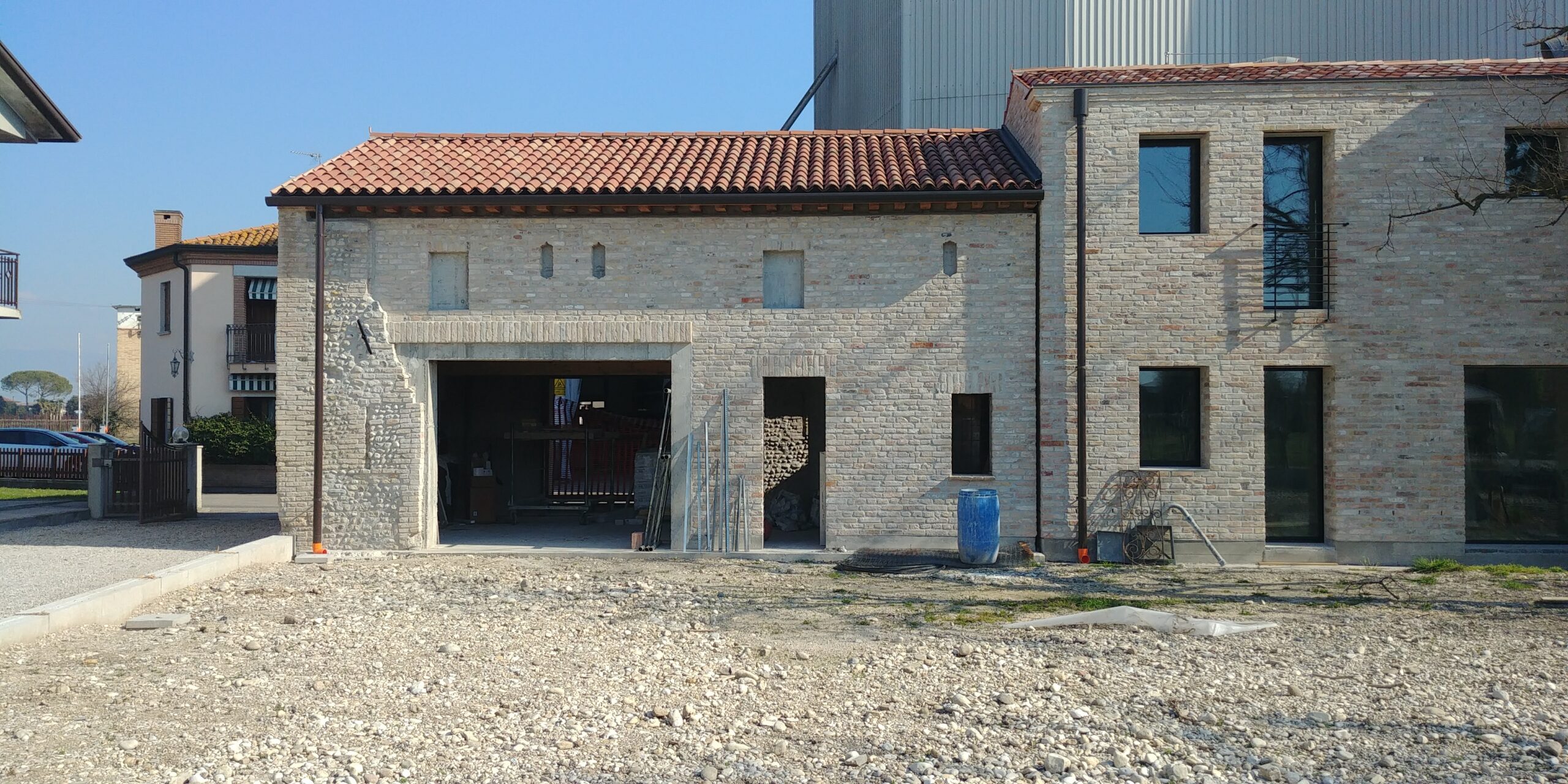 Facciata laterale del casolare rurale ristrutturato con muratura in mattoni e copertura in coppi