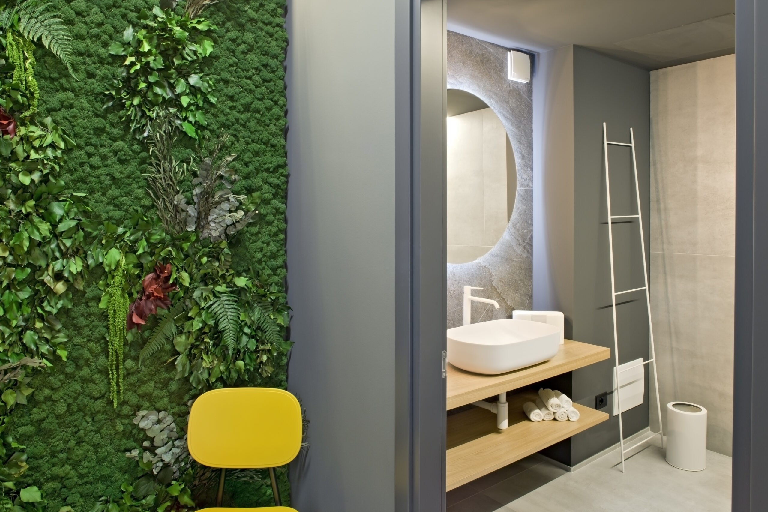 Bagno dell’ufficio con parete verde, lavabo sospeso e finiture contemporanee