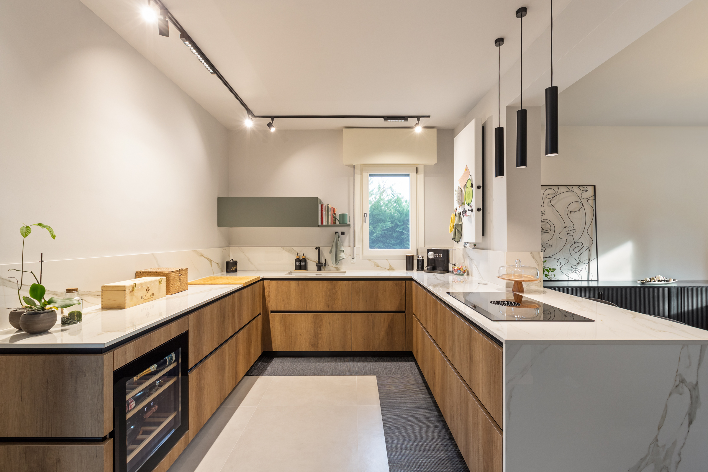 Cucina ristrutturata con arredi in legno e piano chiaro in casa anni Sessanta