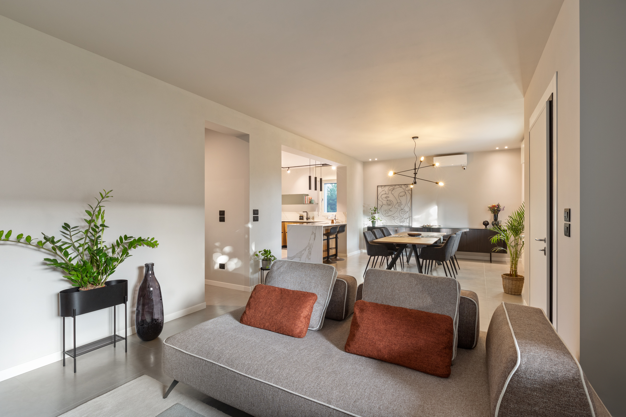 Soggiorno ristrutturato con vista verso zona pranzo e cucina in casa anni Sessanta