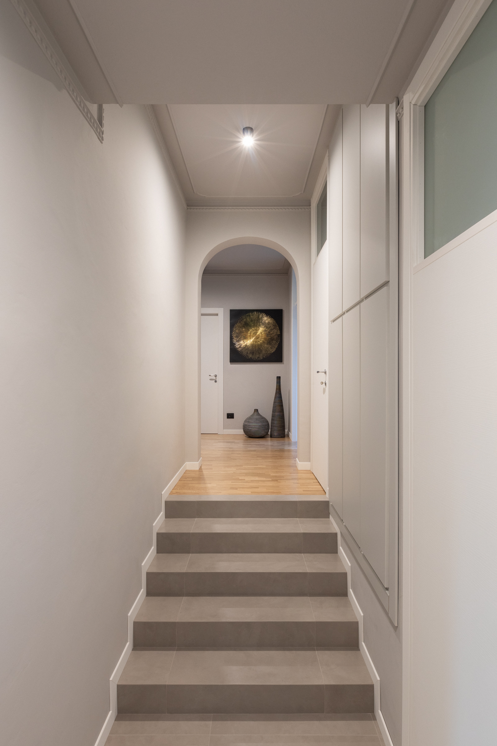 Corridoio ristrutturato con gradini e pavimento in legno in casa anni Sessanta
