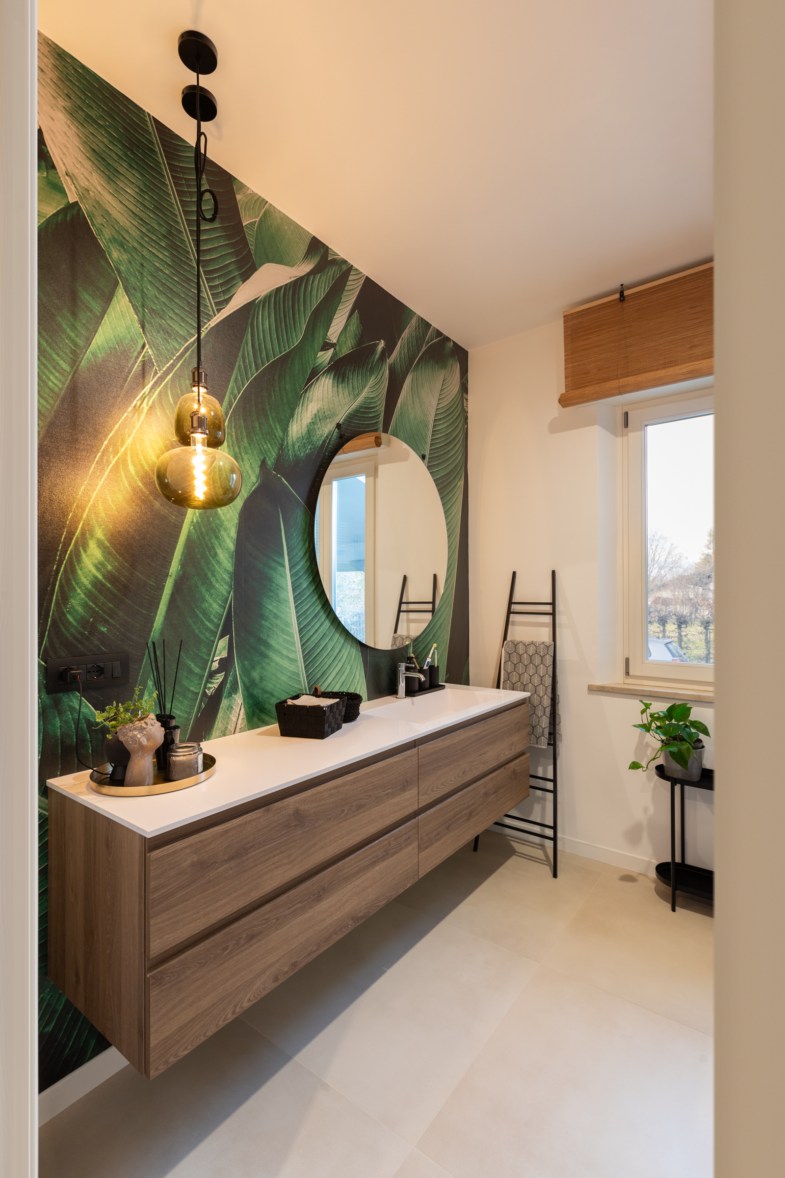 Bagno ristrutturato con mobile sospeso in legno e carta da parati botanica