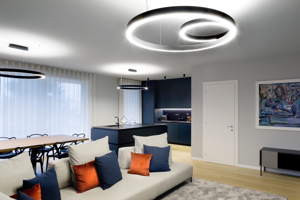 Appartamento GM, zona giorno open space con cucina blu notte e pavimento in legno