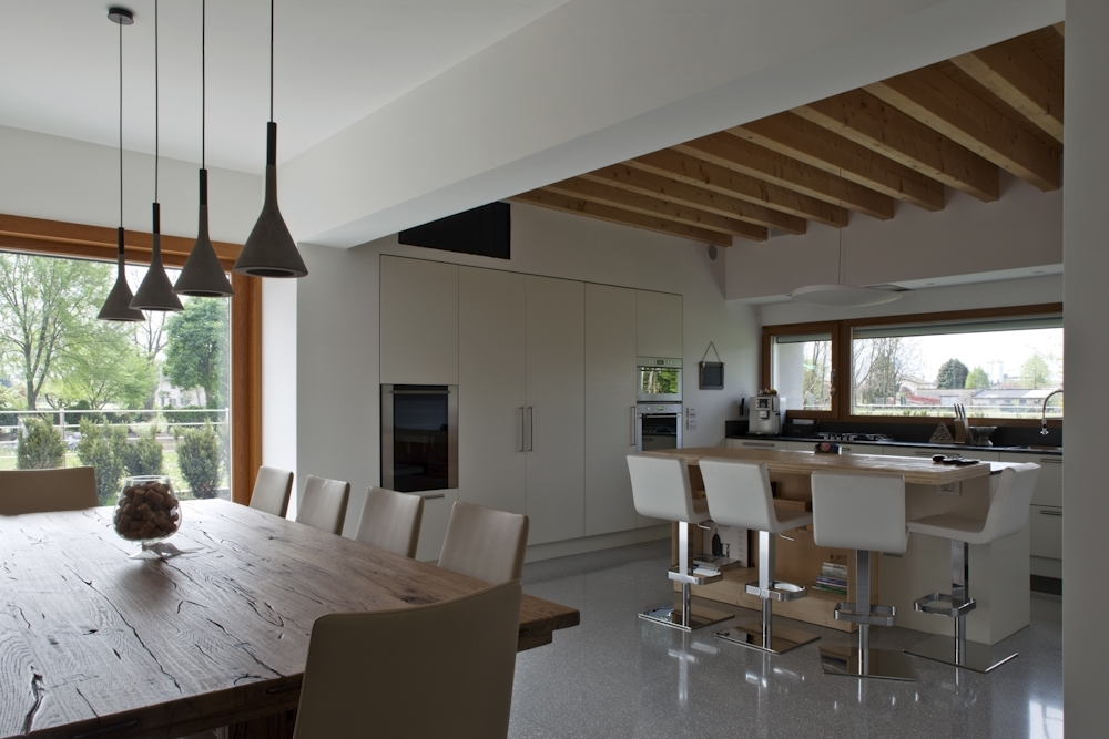 Casa CP, zona pranzo collegata alla cucina con travi in legno a vista