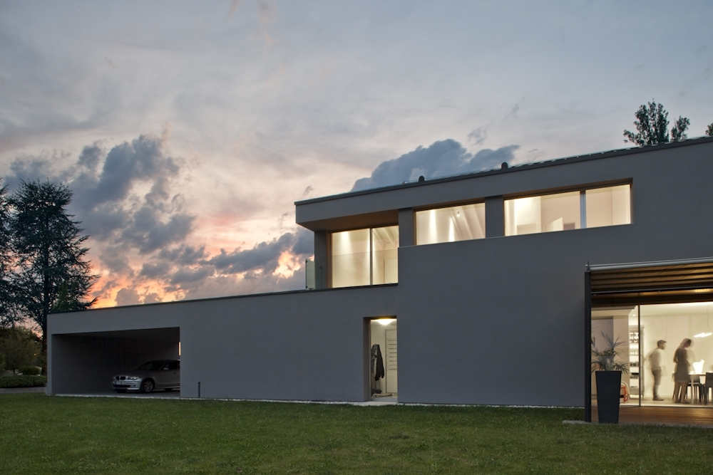 Casa GZ, vista serale della facciata con finestre orizzontali e soggiorno illuminato