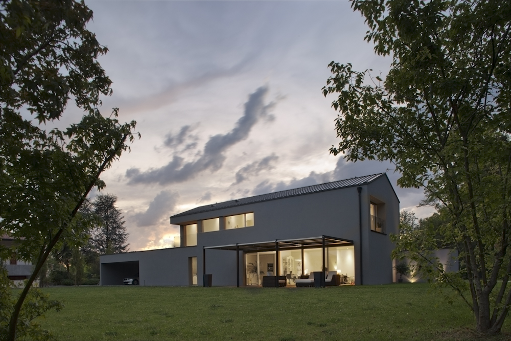 Casa GZ, vista serale della facciata sul giardino con grandi aperture vetrate