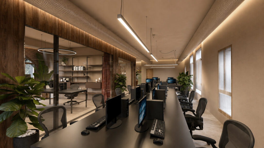 Postazioni operative in open space con parete vetrata, illuminazione lineare e piante integrate nello spazio di lavoro