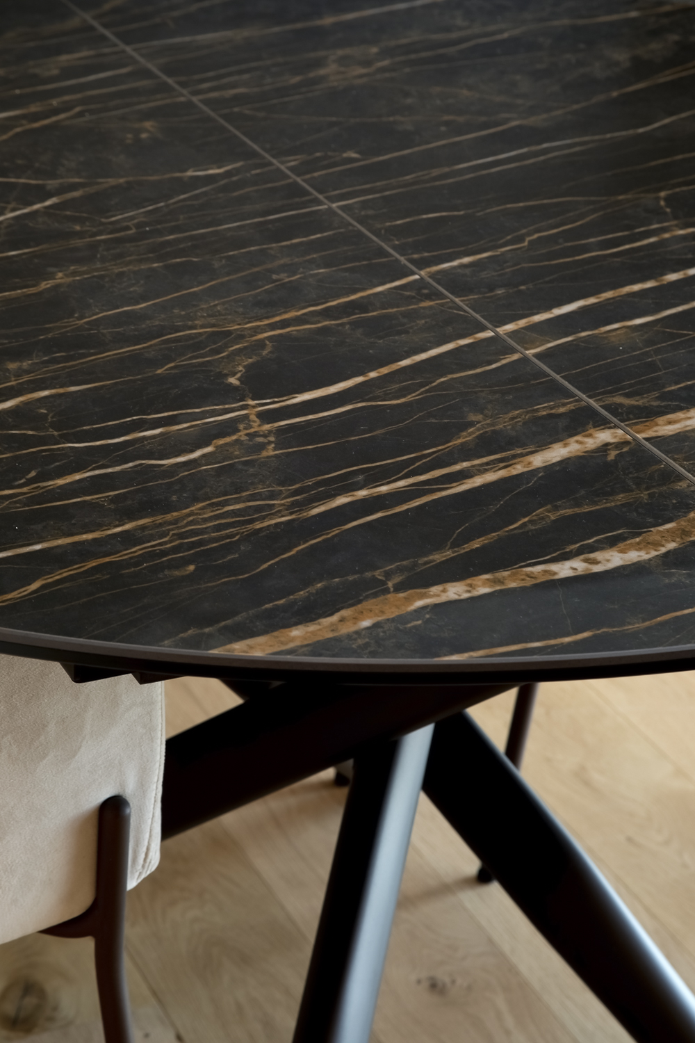 Appartamento C, dettaglio del tavolo da pranzo nero effetto marmo Noir Désir con venature dorate