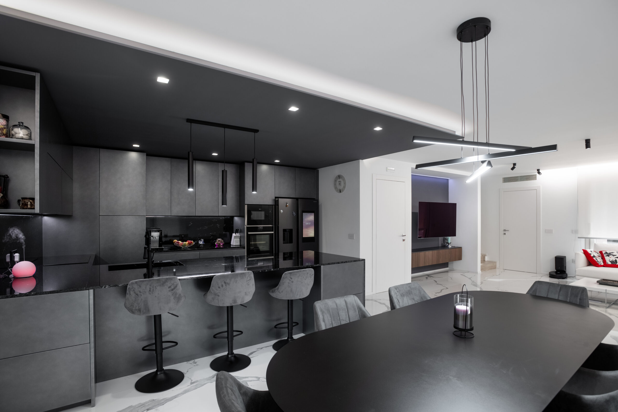 Zona giorno contemporanea con cucina nera, isola centrale e tavolo da pranzo