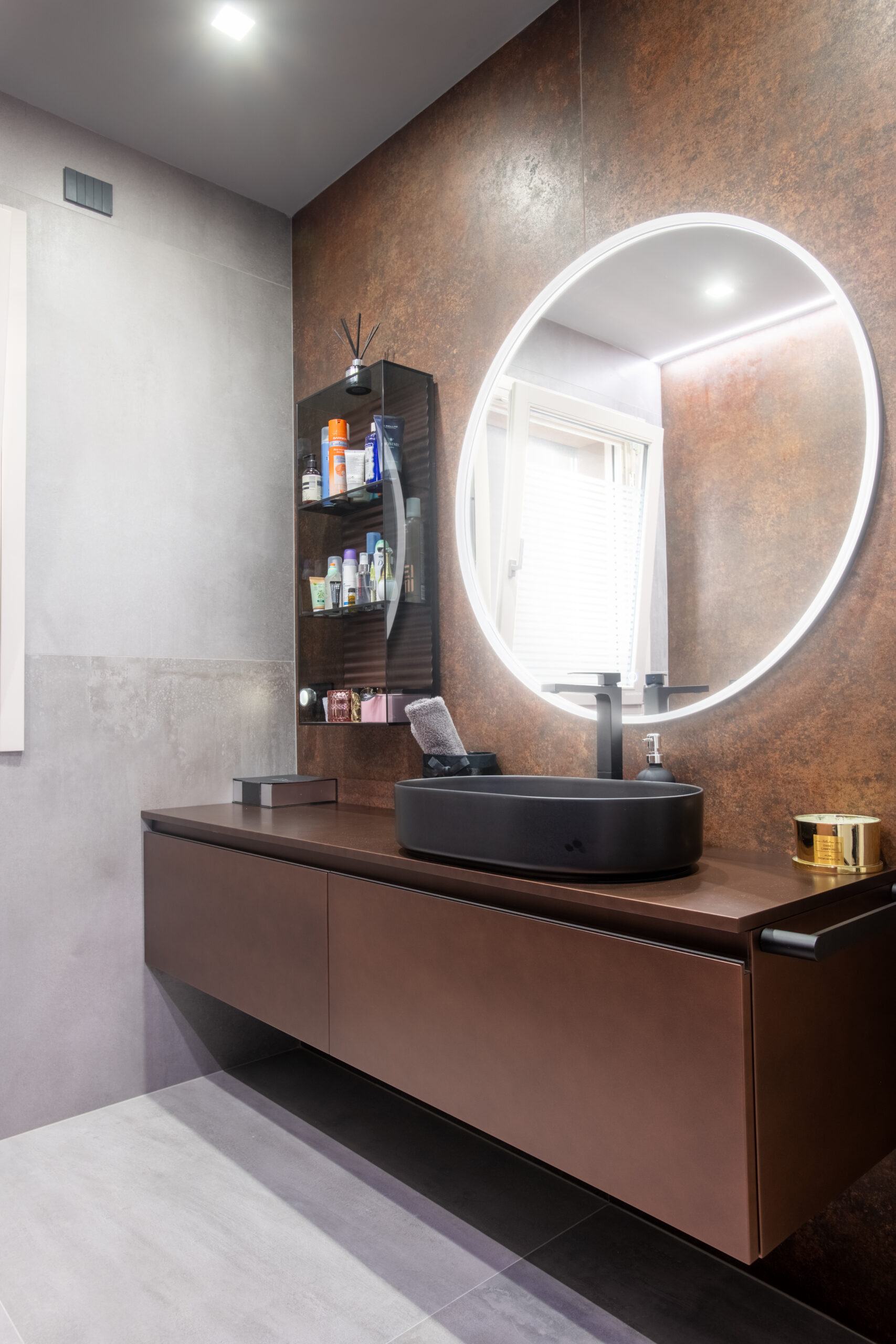 Bagno contemporaneo con mobile lavabo sospeso, specchio retroilluminato e finiture materiche