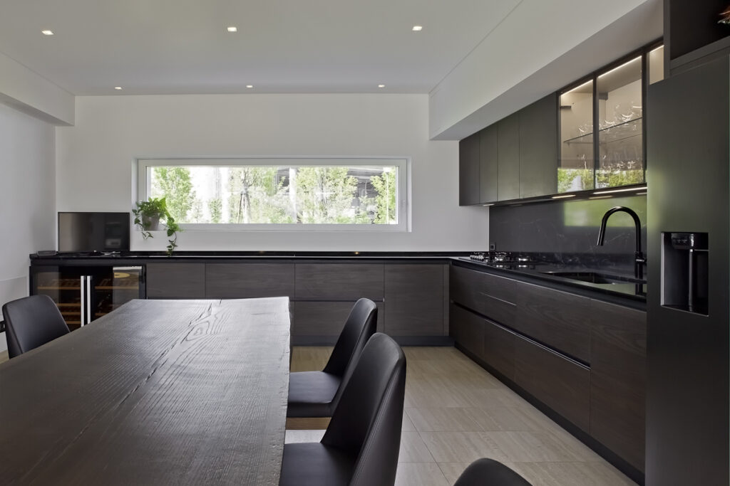 Casa P, cucina contemporanea con arredi in legno scuro, tavolo da pranzo e grande finestra orizzontale